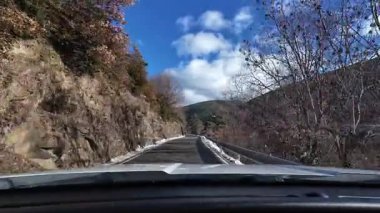 İspanya 'nın La Molina şehrinde kış boyunca virajlı ve karlı bir yolda giden bir arabadan bakış açısı