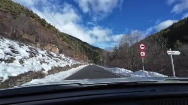İspanya 'nın La Molina şehrinde kış boyunca virajlı ve karlı bir yolda giden bir arabadan bakış açısı