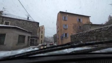 Palau De Cerdagne, Fransa; 24 Ocak 2026: Pirenes dağlarındaki bir köyden geçen karlı bir yoldan çekilen görüntüler