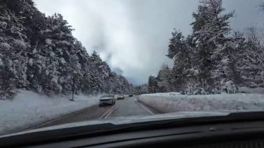 Palau De Cerdagne, Fransa; 24 Ocak 2026: Pirenes dağlarındaki bir köyden geçen karlı bir yoldan çekilen görüntüler