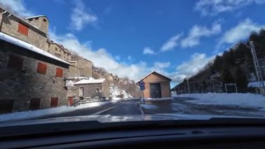 Palau De Cerdagne, Fransa; 24 Ocak 2026: Pirenes dağlarındaki bir köyden geçen karlı bir yoldan çekilen görüntüler