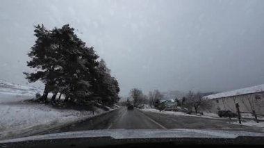 Palau De Cerdagne, Fransa; 24 Ocak 2026: Pirenes dağlarındaki bir köyden geçen karlı bir yoldan çekilen görüntüler