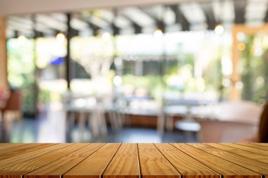 Soyut bulanık bar arkaplanının önündeki tahta masa. Montaj ürünü görüntüleme veya tasarım için görsel anahtar düzeni.