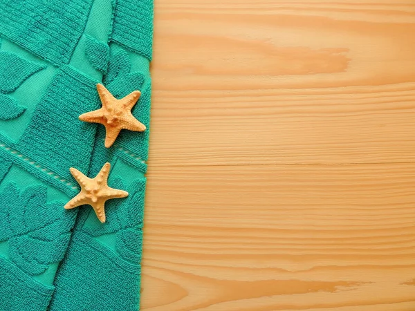 Spa arka plan kopya alanı ile ahşap yüzeyde turkuaz bir havlu ile.