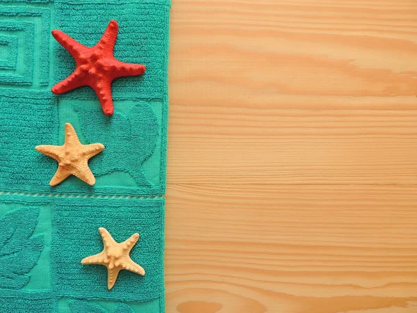 Towel with starfish on wooden surface. — Stock Photo, Image