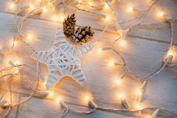 Wooden star with cones and light — Stock Photo, Image