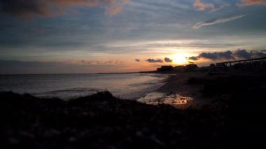 Denizin üzerinde güzel gün batımı. Gökyüzünde küçük bulutlar. Tropikal bölgelerde romantik zaman kavramı.