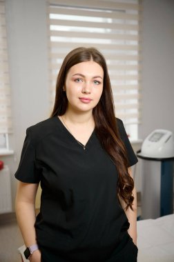 Klinikte, modern tıp kıyafeti giyen güzel bir kadın doktor portresi..