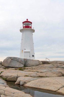 Alacakaranlıkta kayalık bir uçurumun kıyısında bir deniz evi.