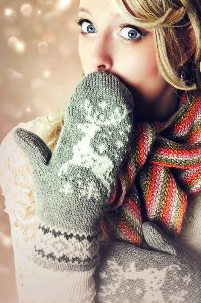 Beautiful blonde surprised woman wearing warm reindeer mittens. Stock Image