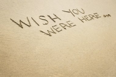 Words wish you were here written in the sand. clipart