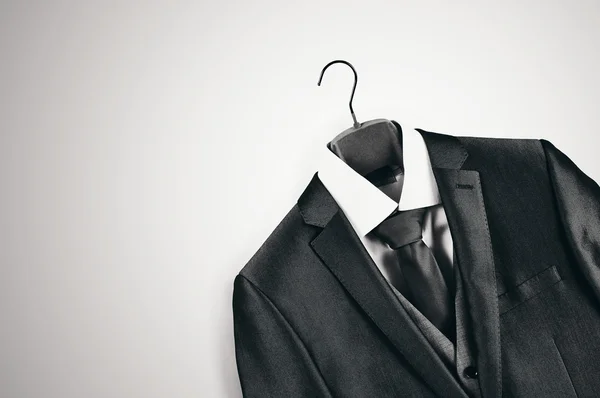 Black and white mens suit on clothes hanger. Stock Photo
