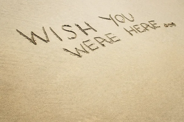 Words wish you were here written in the sand. Royalty Free Stock Images