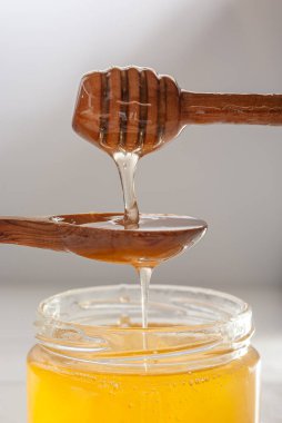 Bal damlıyor bal kutusundan tahta bir kaşığa sonra da cam kavanoza..