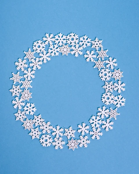 冬の青い背景に木製の雪片で作られた白いフレーム 冬またはクリスマスのコンセプト フラットレイアウト トップビュー コピースペース — ストック写真
