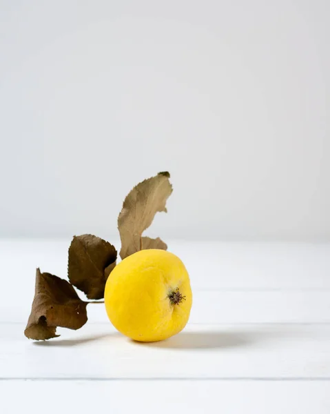 Beyaz ahşap bir masada küçük sarı bahçe elması