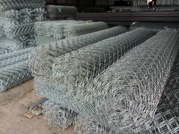 Pile of steel mesh roll. Metal Wire fence roll. Fencing rolled into rolls. Galvanized steel grating in stock. Fence with large cells. Texture, background for steel shops and construction businesses.