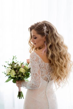 Güzel bir gelinin portresi. Arka planda bir buket var.