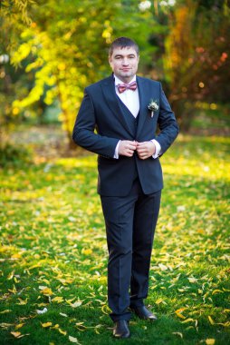 Takım elbiseli damat düğmeleri ilikliyor.