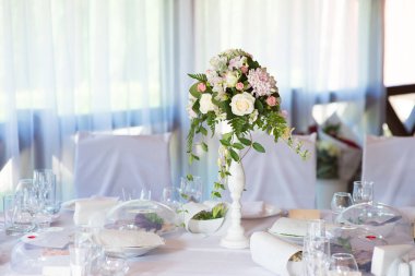 Bir restorandaki ziyafet masasında çiçek kompozisyonu