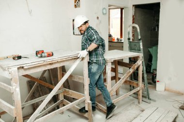 Miğferli bir inşaatçı inşaat alanında çalışıyor.