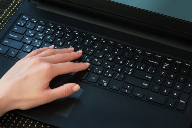 Evde çalışırken dizüstü bilgisayarın anahtarlarını kullanan kadın.