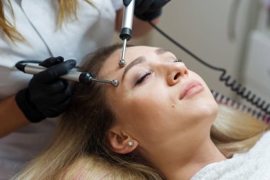 Güzellik uzmanı mikro akımlarla masaj yapıyor.