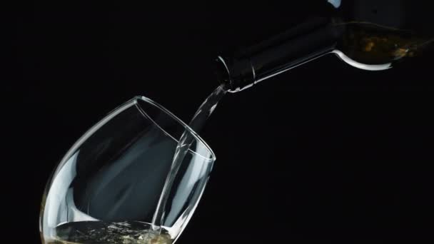 Χύσιμο κρασιού από μπουκάλι. Λευκός οίνος σε ποτήρι — Αρχείο Βίντεο