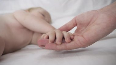 Yeni doğmuş bebek rahat bir yatakta tatlı tatlı uyuyor.