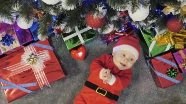 Noel Baba gibi giyinmiş küçük çocuk.