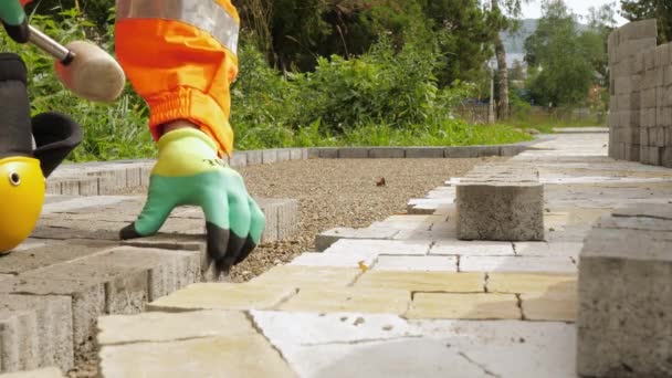 Construction worker makes new sidewalk pavement with stone bricks — Stock Footage Construction worker makes new sidewalk pavement with stone bricks Royalty Free Stock Footage