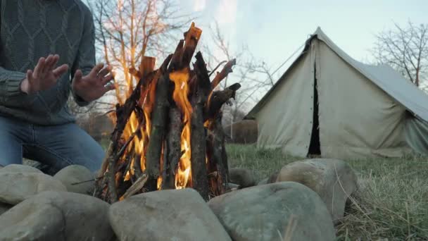 Homem aquece as mãos na frente de uma fogueira — Vídeo de Stock