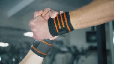 Spor salonunda tokalaşan iki kaslı adam.