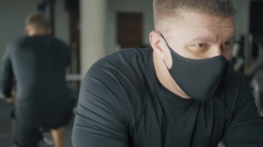 Atletik adam sabit bisiklet eğitimi alıyor.