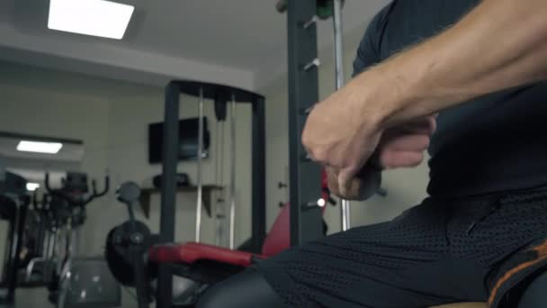 Muscular levantador de pesas aplicando vendaje elástico en su muñeca en el gimnasio — Vídeo de stock