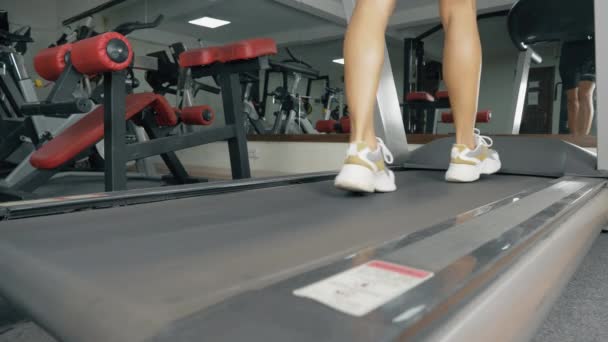Молодая спортсменка бежит на беговой дорожке в спортзале. — стоковое видео