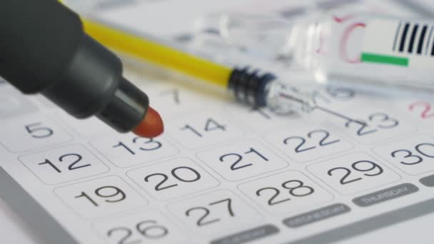 Siringa e fiala con vaccino su un calendario a parete — Video Stock