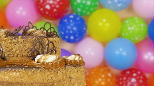 Schokoladenkuchen mit bunten Luftballons — Stockvideo