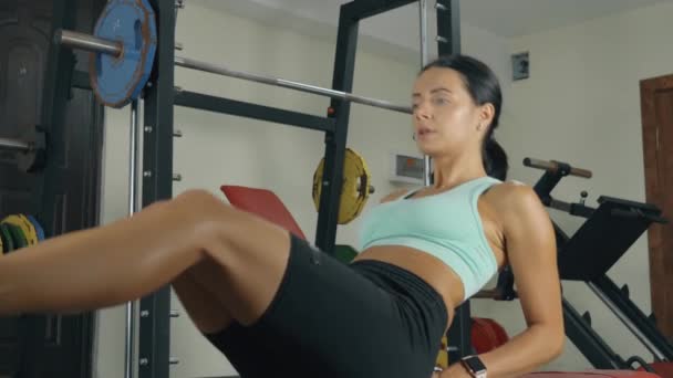 Woman pumping up abs muscles at the gym — Stock Video