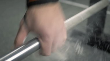 Spor salonunda sporcu halteri kaldırır.