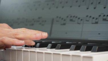 Genç bir kadın klavyede şarkı çalıyor.