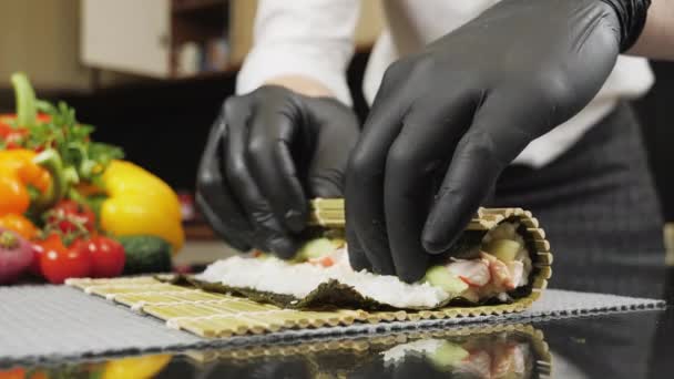 Cook händer gör japansk sushi rulle med bambu matta. — Stockvideo