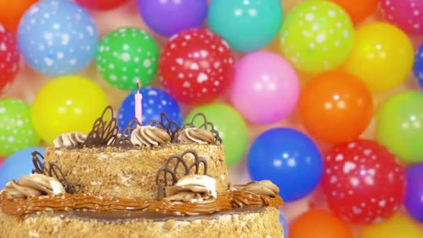 Tarta de cumpleaños con globos varicolores sobre un fondo — Vídeo de stock