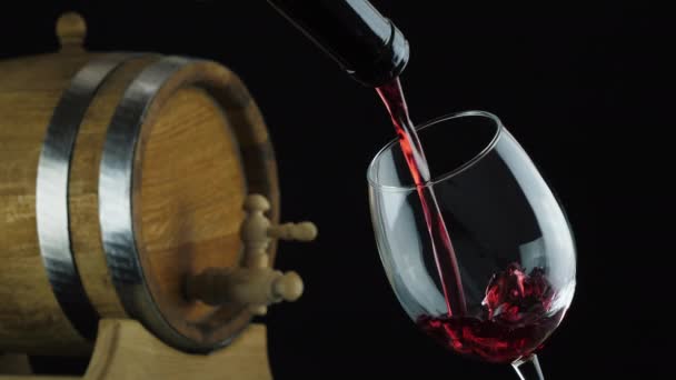 Vino tinto se vierte desde el cuello de la botella en el vaso — Vídeos de Stock