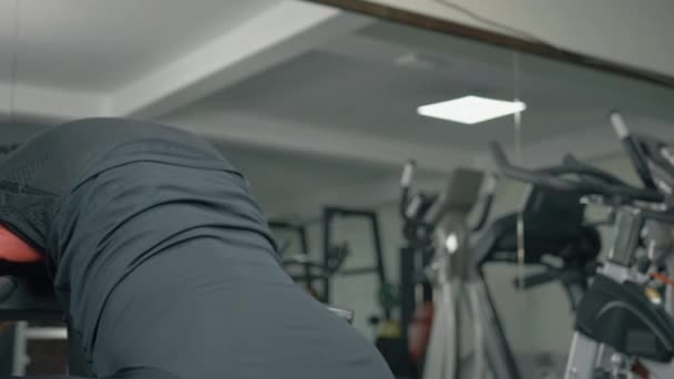 El culturista entrena los músculos inferiores de la espalda en un club de fitness — Vídeos de Stock