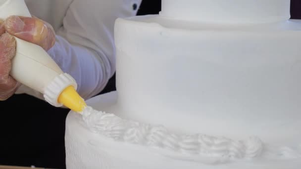 Kokken dekorerer en kake med fløte på bakeriet – stockvideo