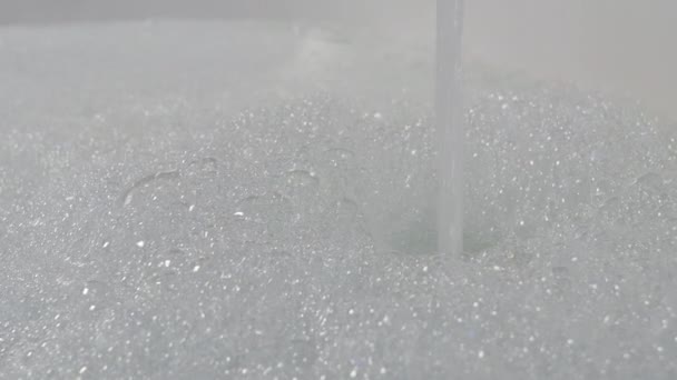 Вода льется в ванну с пузырьковой пеной — стоковое видео