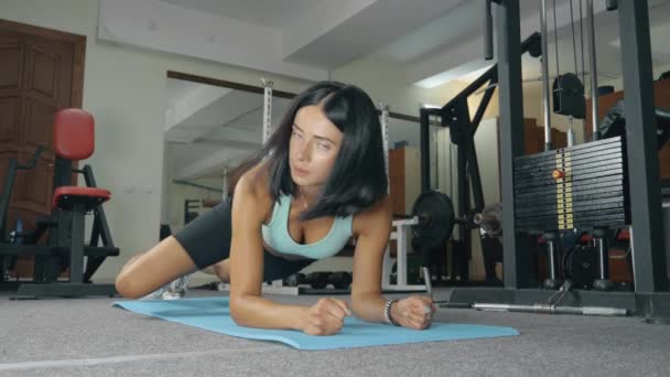 Fitness fille en tenue de sport faisant une planche. — Video