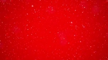 Kar taneleri parlak kırmızı bir zemin üzerine yavaşça inerek çarpıcı bir görsel kontrast oluştururlar. Bu sahne, neşeli bir atmosferle huzurlu bir anı yakalar..