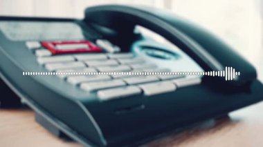 Bir ahşap masanın üzerindeki telefonun yakın plan görüntüsü, ses kayıt dalgası görüntüleniyor. Arka plan hafifçe bulanık, aygıtı ve ses görselleştirmesini vurguluyor.